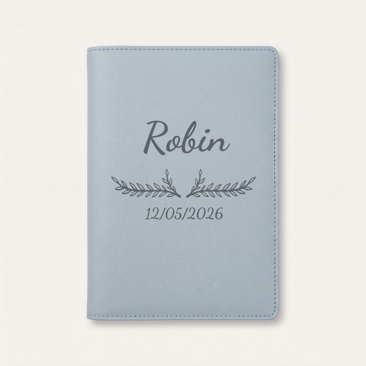 Protège carnet de santé personnalisé Robin — Bleu nuage — prénom « Robin », ornement Bouquet et date de naissance « 12/05/2026 » gravés
