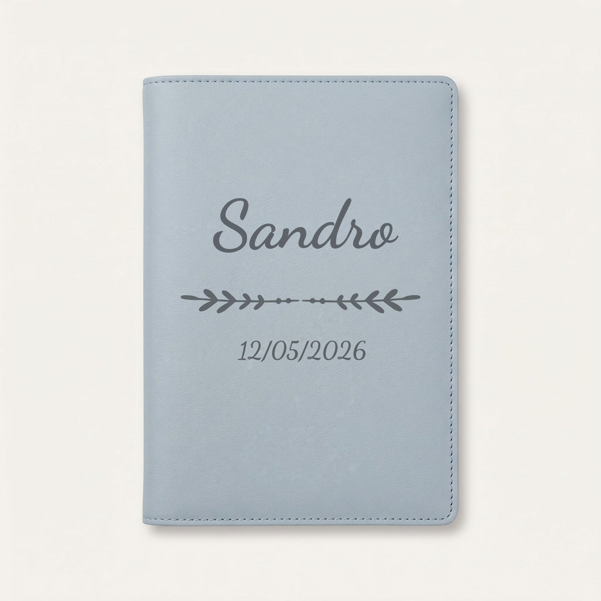 Protège carnet de santé personnalisé Sandro — Bleu nuage — prénom « Sandro », ornement Flèche et date de naissance « 12/05/2026 » gravés