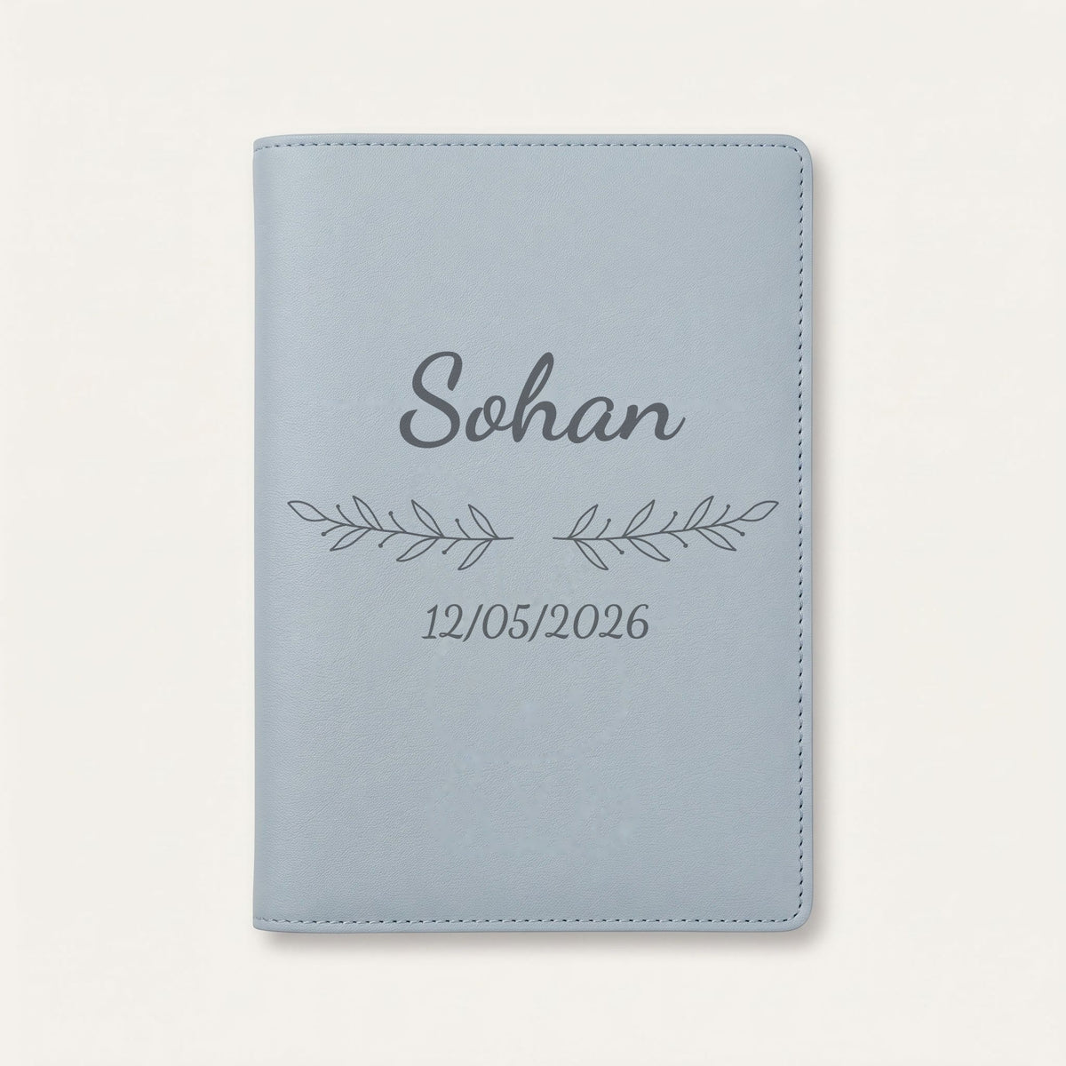 Protège carnet de santé personnalisé Sohan — Bleu nuage — prénom « Sohan », ornement Rameaux et date de naissance « 12/05/2026 » gravés