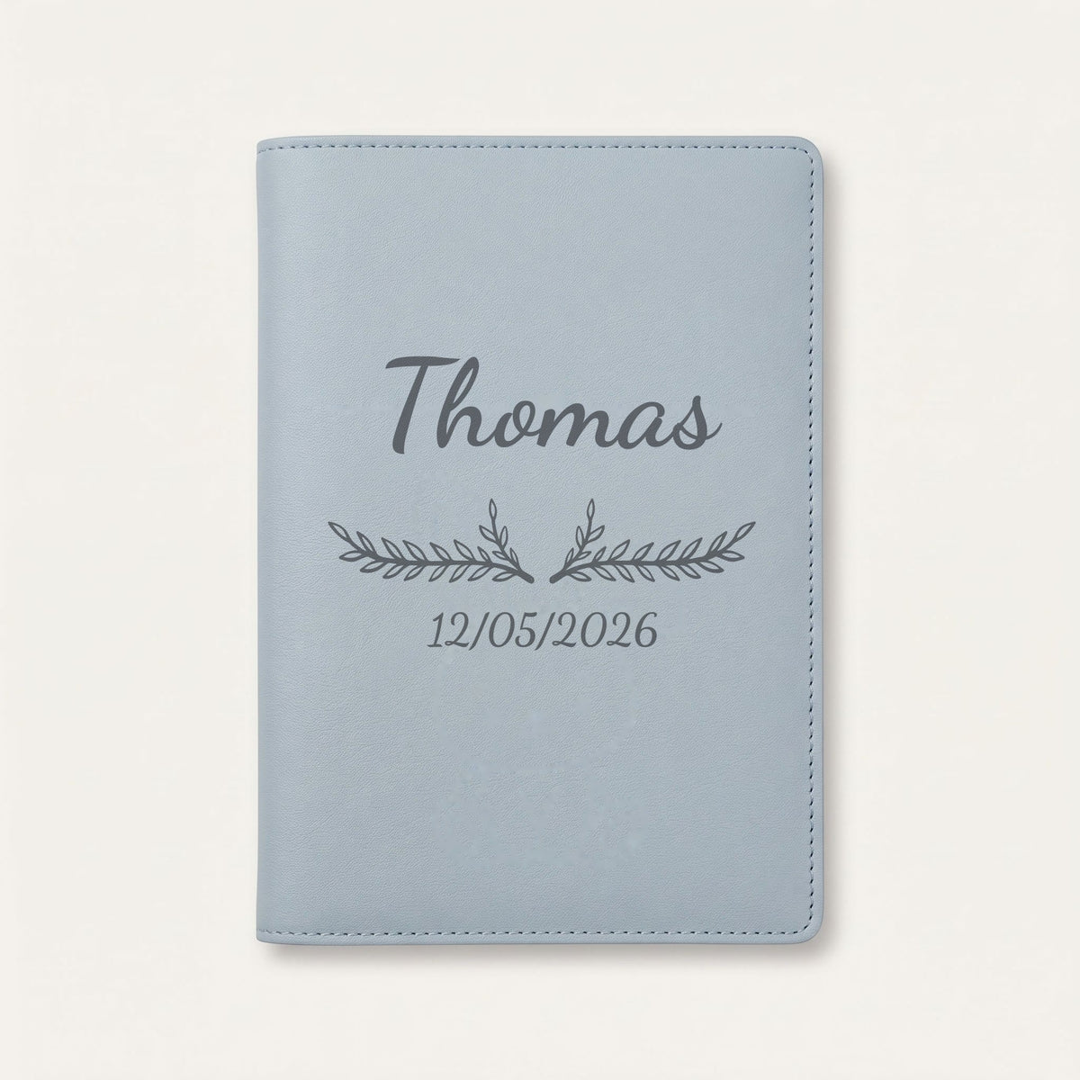 Protège carnet de santé personnalisé Thomas — Bleu nuage — prénom « Thomas », ornement Bouquet et date de naissance « 12/05/2026 » gravés