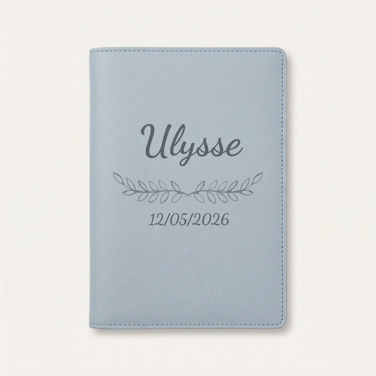 Protège carnet de santé personnalisé Ulysse — Bleu nuage — prénom « Ulysse », ornement Feuillage et date de naissance « 12/05/2026 » gravés