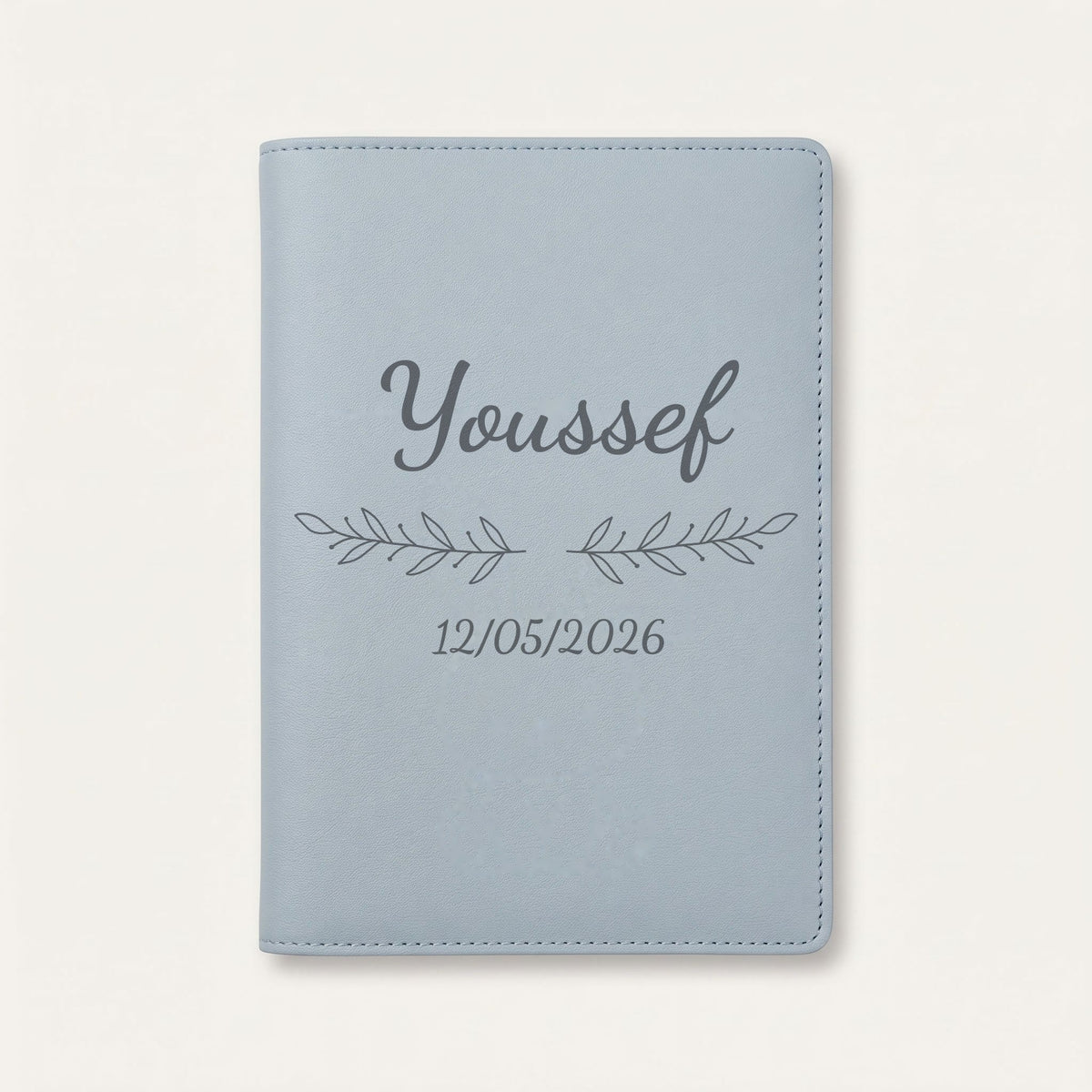 Protège carnet de santé personnalisé Youssef — Bleu nuage — prénom « Youssef », ornement Rameaux et date de naissance « 12/05/2026 » gravés